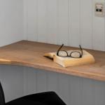Schreibtisch mit Buch und Brille in Ecke