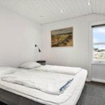 Schlafzimmer mit Bett, Fenster und Wandbild.