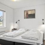 Schlafzimmer mit Doppelbett, Fenster und Wandbild.