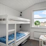 Zimmer mit Doppelstockbett, Fenster und Tisch.