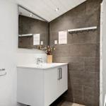 Badezimmer mit Waschbecken, Spiegel und Dusche