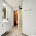 Flur mit Waschbecken, Spiegelschrank und Blick in Sauna.