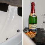 Badewanne mit Massagefunktion und Sekt mit Gläsern und Nüssen.