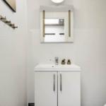 Badezimmer mit Waschbecken, Spiegel und Pflanzen