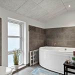 Badezimmer mit Badewanne, Fenster und Toilette
