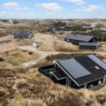 Dorf mit Häusern auf Dünen, einige mit Solaranlagen
