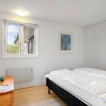 Schlafzimmer mit Doppelbett, weißer Einbauschränke und Holzoberfläche.