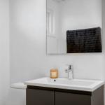 Badezimmer mit Waschbecken, Spiegel und Handtuch.