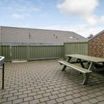 Terrasse mit Picknicktisch, umgeben von Holz- und Ziegelmauer.