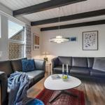 Wohnzimmer mit zwei Sofas, Tisch und Fenstern.