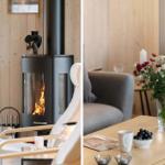 Wood-burning stove, gray sofa, table with flowers and fruit.