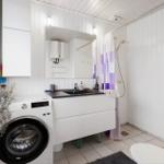 Bathroom with washing machine, shower, and mirror