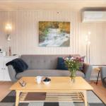 Living room with sofa, coffee table, and wall art. Kitchen area in background.