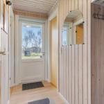 Entrance area with wooden wall, mirror, and door to outdoor area.