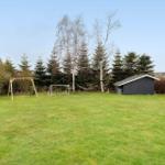 Green lawn with fire pit, swing, soccer goal, and shed.