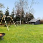 Backyard with fire pit, swing, soccer goal, and small shed.