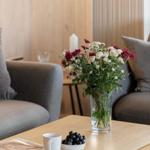 A table with flowers, coffee cup, and grapes in the living area.