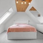 Schlafzimmer mit Dachschrägen, Bett und Fenster