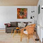 Wohnzimmer mit Sofa, Stuhl und Wandbild.
