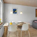 Essbereich mit Tisch, Stühlen und Sofa. Fenster mit Blumen und Wandbilder.