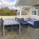 Deck with table, chairs, and sofa under roof.