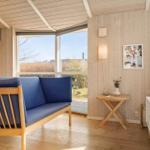 Living room with blue sofa, wooden walls, and large window view.