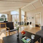Living and dining area with fireplace, large windows, and wooden elements.