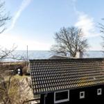 Black house with roof and windows by the water
