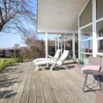 Deck with lounge chairs and seating group, view of tree and landscape.