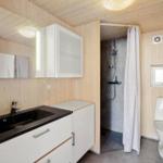 Bathroom with shower, toilet, and sink with mirror.