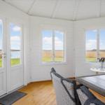 Wohnraum mit Blick auf Wasser und Grasland durch große Fenster und Tür.