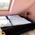 Schlafzimmer mit Dachschrägen, Bett, Fenster und Nachttisch.