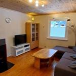 Wohnzimmer mit Sofa, Fernseher und Holztisch.