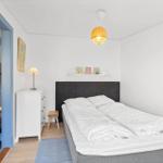 Bedroom with bed, nightstand, stool, and duvet. Door leads to a closet.