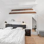 Bedroom with sloped ceiling, bed, nightstand, and window