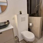 Badezimmer mit Waschbecken, Toilette und Dusche.
