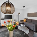 Wohnzimmer mit Sofa, Fernseher und Tulpen auf Tisch
