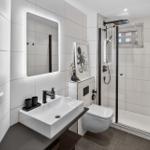 Badezimmer mit Dusche, Waschbecken und Toilette.