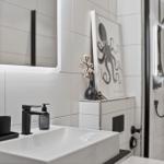 Badezimmer mit Waschbecken, Spiegel und Dusche