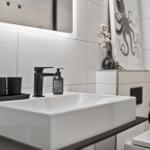 Badezimmer mit Waschbecken, Spiegel und Dusche
