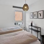 Schlafzimmer mit Bett, Fenster und Wanddekoration.