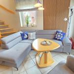 Wohnzimmer mit grauem Sofa, Holztisch und Treppe zur Galerie.