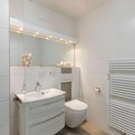 Badezimmer mit Waschbecken, Spiegel und Toilette
