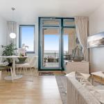 Wohnzimmer mit Essbereich und Balkonblick aufs Meer.