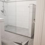 Bad mit Dusche, Toilette und Sternmusterbodenfliesen.