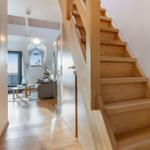 Holztreppe führt zu einer Wohnung mit Wohnbereich und Meerblick.