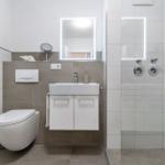 Badezimmer mit Dusche, Waschbecken und Toilette.