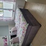 Schlafzimmer mit Bett, Fenster und Wandbild