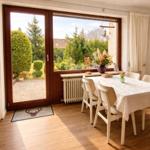 Esszimmer mit Tisch, Stühlen und Blick auf den Garten.