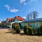 Grünes Haus mit Solaranlage und Terrasse im Freien.